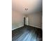 Neutral-toned bedroom with wood-look flooring, a door, and a ceiling light at 1987 Robert Rufty Ln, Catawba, NC 28609