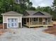 Charming single-Gathering home featuring a covered porch, neutral siding, and a detached garage in a wooded neighborhood at 1987 Robert Rufty Ln, Catawba, NC 28609