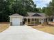 Welcoming home with a covered porch and a detached garage, complemented by a newly paved driveway at 1987 Robert Rufty Ln, Catawba, NC 28609