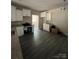 An open kitchen showcases bright cabinets, granite counters, and dark gray wood-look flooring at 1987 Robert Rufty Ln, Catawba, NC 28609