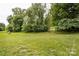 Lush green backyard with a level lawn and mature trees, offering a peaceful and private outdoor setting at 2024 Stonewyck Ave, Kannapolis, NC 28081