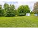 Spacious backyard with lush green lawn, mature trees, and a storage shed, providing a private outdoor space at 2024 Stonewyck Ave, Kannapolis, NC 28081