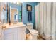 Stylish bathroom with blue walls, a decorative mirror, and a white vanity at 2024 Stonewyck Ave, Kannapolis, NC 28081