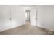 Clean bedroom with plush carpeting, light walls, and multiple entry points for easy accessibility at 210 N Correll St, Landis, NC 28025