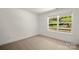 Light and airy bedroom with neutral carpet, white walls, and a large sunny window at 212 N Correll St, Landis, NC 28025