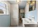 Modest bathroom featuring blue tiled walls, white fixtures, and a window offering natural light at 217 S Highland St, Gastonia, NC 28052