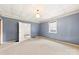 Spacious carpeted bedroom with light blue walls, featuring an open doorway and a bright window at 217 S Highland St, Gastonia, NC 28052