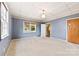 Well-lit bedroom featuring blue paneling, plush carpeting, and a sunlit window at 217 S Highland St, Gastonia, NC 28052