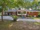 Rear exterior view shows access ramp, sunroom, brick, carport, and mature landscaping on a spacious lot at 2216 Griffith Rd, Monroe, NC 28112