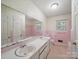 Retro bathroom featuring double vanity, pink tile, and classic fixtures for a vintage aesthetic at 2216 Griffith Rd, Monroe, NC 28112