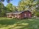 Side view of a brick home with lush green lawn and mature trees, offering a serene setting at 2216 Griffith Rd, Monroe, NC 28112
