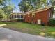 Exterior of brick home shows access ramp, sunroom, and mature landscaping on a spacious lot at 2216 Griffith Rd, Monroe, NC 28112