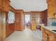 Retro kitchen with wooden cabinets, a built-in desk area, and convenient access to other rooms at 2216 Griffith Rd, Monroe, NC 28112