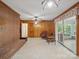 Spacious living area with brick fireplace, wood paneling, and access to sunroom at 2216 Griffith Rd, Monroe, NC 28112