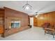 Cozy living area featuring a brick fireplace, built-in shelving, and wood paneled walls at 2216 Griffith Rd, Monroe, NC 28112