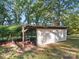 Exterior shot of the backyard outbuilding on a grass lot with an open ladder attached to the back at 2216 Griffith Rd, Monroe, NC 28112