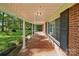 Long, covered porch with tiled floor, brick walls, and white columns, offering a relaxing outdoor space at 2216 Griffith Rd, Monroe, NC 28112