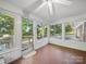 Bright sunroom with many windows, ceiling fan, and unique tile flooring looking out to the lovely landscaped outdoors at 2216 Griffith Rd, Monroe, NC 28112