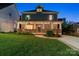 Beautifully lit two-story home at dusk, showcasing a charming front porch and well-manicured lawn at 2217 Yadkin Ave, Charlotte, NC 28205