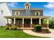 Charming two-story home featuring a welcoming front porch with stylish wood and brick accents at 2217 Yadkin Ave, Charlotte, NC 28205