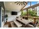 Inviting screened porch with a dining table, seating and a TV, perfect for outdoor entertaining and relaxation at 2217 Yadkin Ave, Charlotte, NC 28205