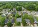 Aerial view of a neighborhood with mature trees and green lawns with a view of the wooded area at 252 Sweet Bay Nw Ln, Concord, NC 28027
