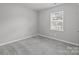 Minimalist bedroom featuring a neutral color scheme, carpeted floor, and a bright window at 252 Sweet Bay Nw Ln, Concord, NC 28027