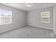 Sunlit bedroom showcasing dual windows that brighten the neutral interior and carpeted floor at 252 Sweet Bay Nw Ln, Concord, NC 28027