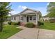 Well-maintained single-story home with a front porch, green lawn, and a detached shed in the backyard at 252 Sweet Bay Nw Ln, Concord, NC 28027