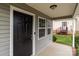 Inviting front porch featuring a black front door, gray siding, and a glimpse of the backyard at 252 Sweet Bay Nw Ln, Concord, NC 28027