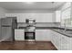 Updated kitchen features white cabinets, stainless steel appliances, and dark countertops, offering ample counter space at 252 Sweet Bay Nw Ln, Concord, NC 28027