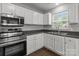 Well-lit kitchen featuring stainless steel appliances, ample white cabinetry, and a double basin sink at 252 Sweet Bay Nw Ln, Concord, NC 28027