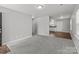 Bright living room featuring gray carpet, fresh paint, and an open layout leading to the kitchen at 252 Sweet Bay Nw Ln, Concord, NC 28027