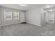 Open-concept living room with gray carpet, white trim, and large windows providing ample natural light at 252 Sweet Bay Nw Ln, Concord, NC 28027