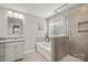 Bright bathroom featuring a glass enclosed shower and soaking tub near a window at 3009 Lydney Cir, Waxhaw, NC 28173