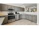 Bright kitchen featuring stainless steel appliances, gray cabinets and light gray floors with a view into the living room at 3071 Des Prez Ave, Fort Mill, SC 29707