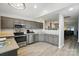 Modern kitchen features gray cabinetry, stainless steel appliances, and a pass-through window to the living area at 3071 Des Prez Ave, Fort Mill, SC 29707