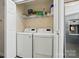 A laundry room with a washer and dryer, along with shelving above for storage near the kitchen area at 3071 Des Prez Ave, Fort Mill, SC 29707