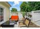 Charming patio with orange sofa, coffee table, chairs, and privacy fence surrounded by lush greenery at 3071 Des Prez Ave, Fort Mill, SC 29707