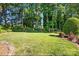 Expansive backyard featuring a well-maintained lawn, mature trees, and vibrant landscaping at 308 Odell St, Kannapolis, NC 28083