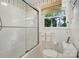 Bathroom featuring a tub with a shower and glass door, along with a toilet at 308 Odell St, Kannapolis, NC 28083