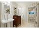 Bathroom featuring dual pedestal sinks, a dresser, and elegant striped wallpaper at 308 Odell St, Kannapolis, NC 28083