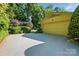 A single car attached garage with mature landscaping and a paved driveway at 308 Odell St, Kannapolis, NC 28083