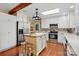 Spacious kitchen featuring white cabinetry, hardwood floors, island, and stainless steel appliances at 308 Odell St, Kannapolis, NC 28083