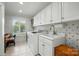 Bright laundry room featuring white cabinets, a sink, and a washer and dryer set at 308 Odell St, Kannapolis, NC 28083