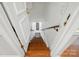 Staircase descending with wooden steps, white walls, and a wooden handrail at 308 Odell St, Kannapolis, NC 28083