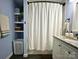 Well-organized bathroom featuring sleek tile floor, storage shelves and bathtub shower with curtain at 329 Highland Dr, Lincolnton, NC 28092