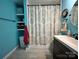 Well-lit bathroom with blue walls, a patterned shower curtain, and modern fixtures at 329 Highland Dr, Lincolnton, NC 28092