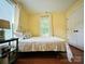 Bright bedroom with yellow walls, hardwood floors, white trim, and a comfortable bed at 329 Highland Dr, Lincolnton, NC 28092