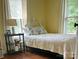 Charming bedroom featuring a comfortable bed, hardwood floors, and bright natural light from two windows at 329 Highland Dr, Lincolnton, NC 28092
